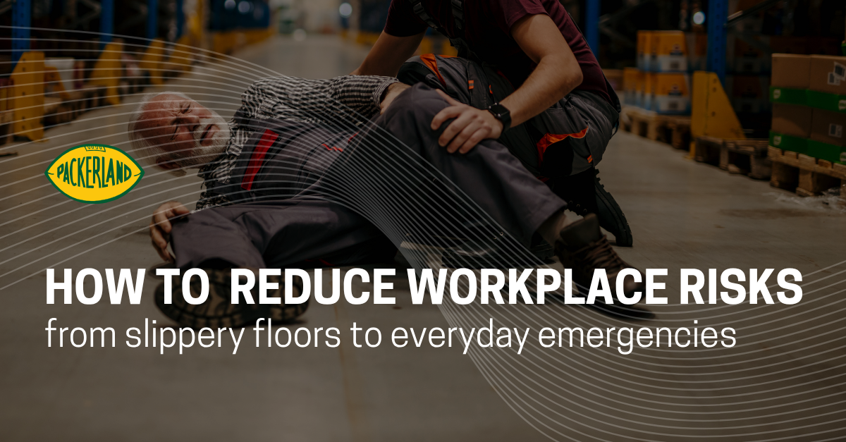 A man in his 60's lays on the floor clutching his legs and hips, his face visibly in pain. Next to him, another man whose face is not shown is crouching down to try to assist the injured man. He is wearing a red apron. Behind them are pallets of items that are slightly blurred, suggesting they are at work.