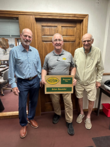 5 Michael Schultz and John Schultz Sr. pose with Brian Baumler, who holds his dedicated parking spot plaque.